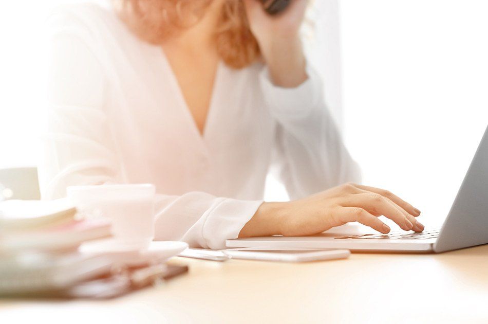 Femme travaillant sur un ordinateur dans une pièce lumineuse