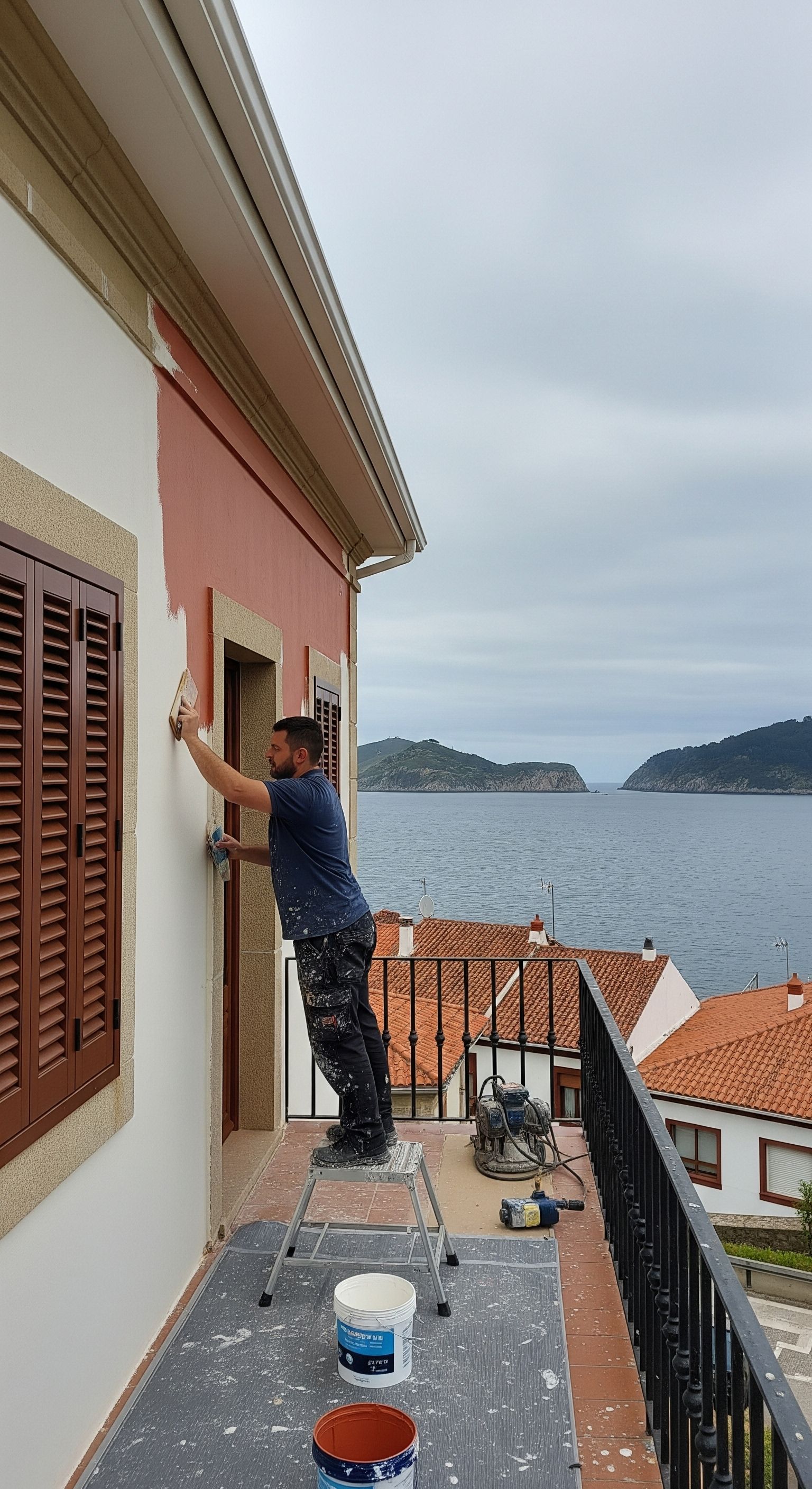 Una mujer sostiene un balde de pintura y rodillos de pintura.