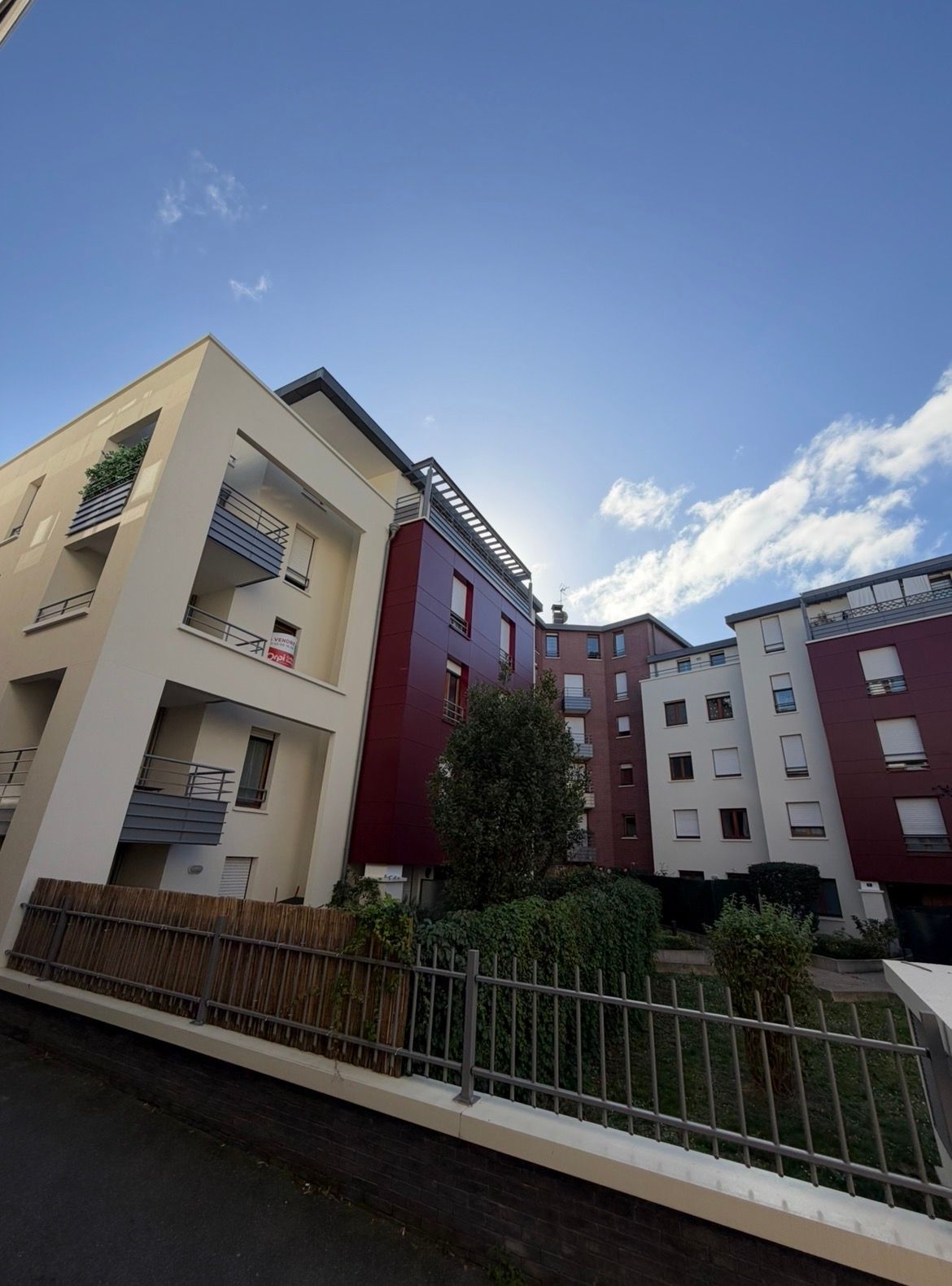 Des immeubles d'appartements modernes aux façades de différentes couleurs sous un ciel bleu.