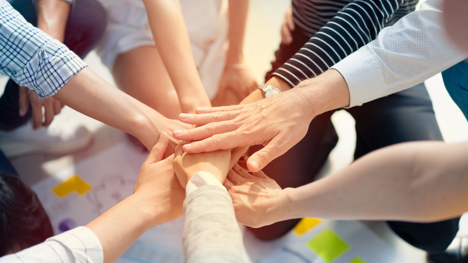 Mains de personnes diverses empilées ensemble dans un symbole de travail d'équipe et de collaboration.