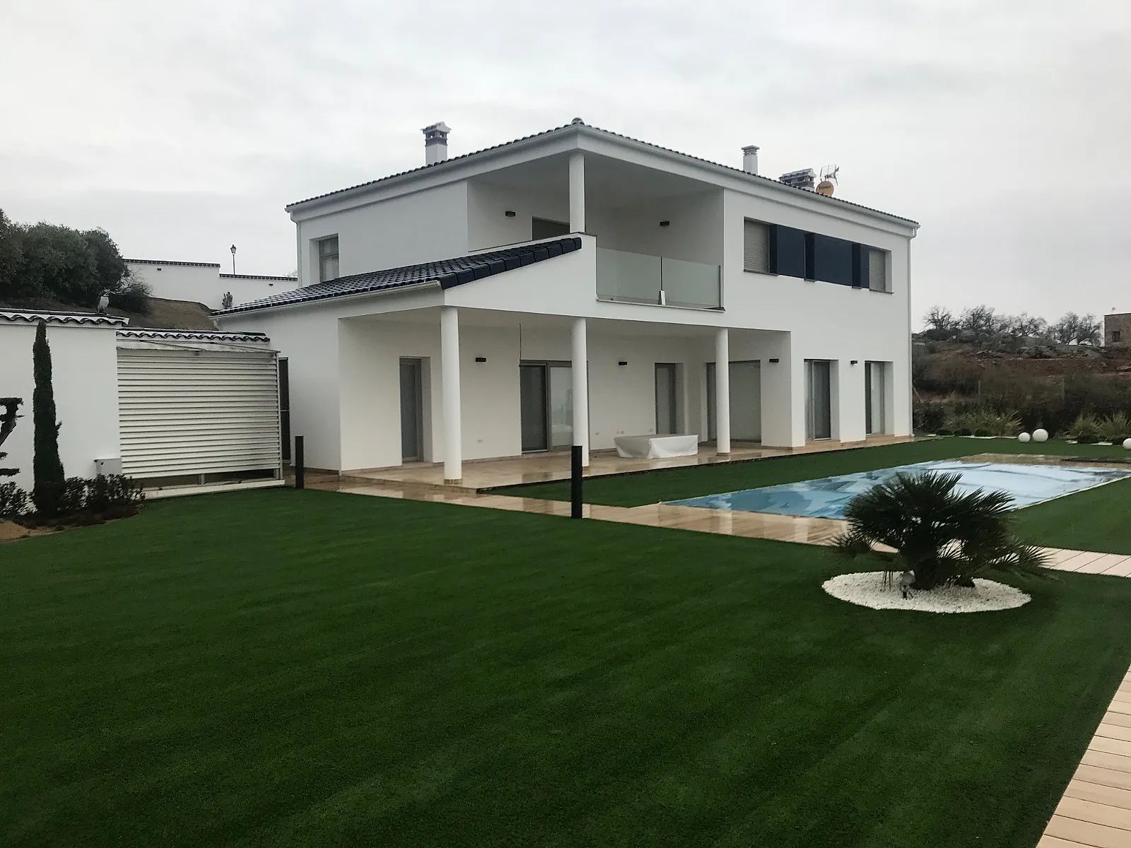 Una casa blanca con piscina en el patio trasero