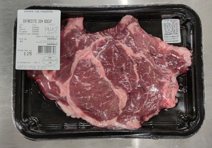 Un trozo de carne cruda está en un recipiente de plástico.