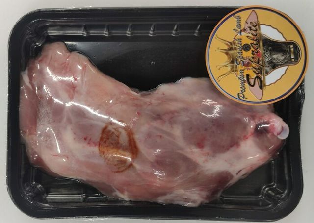 Un trozo de carne en un recipiente de plástico con una etiqueta.