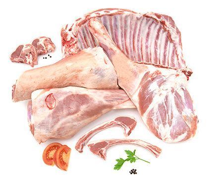 Un montón de carne cruda con tomates y perejil sobre un fondo blanco.
