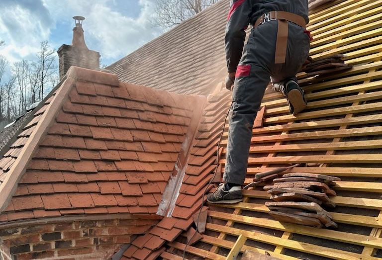 Couvreur qui rénove une toiture