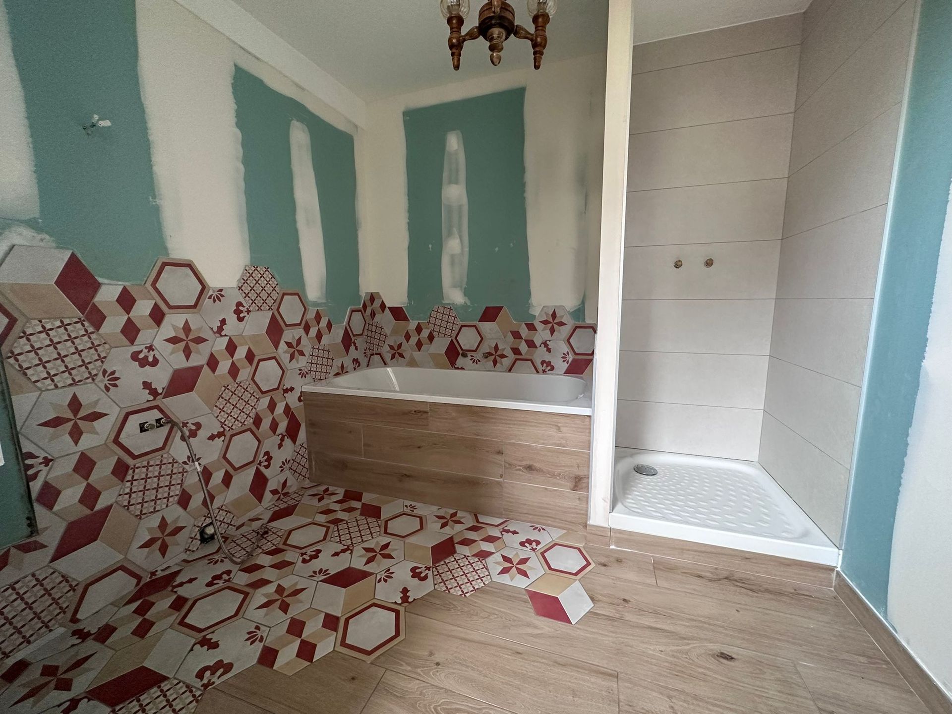 Salle de bains avec sol en parquet et mosaïque.