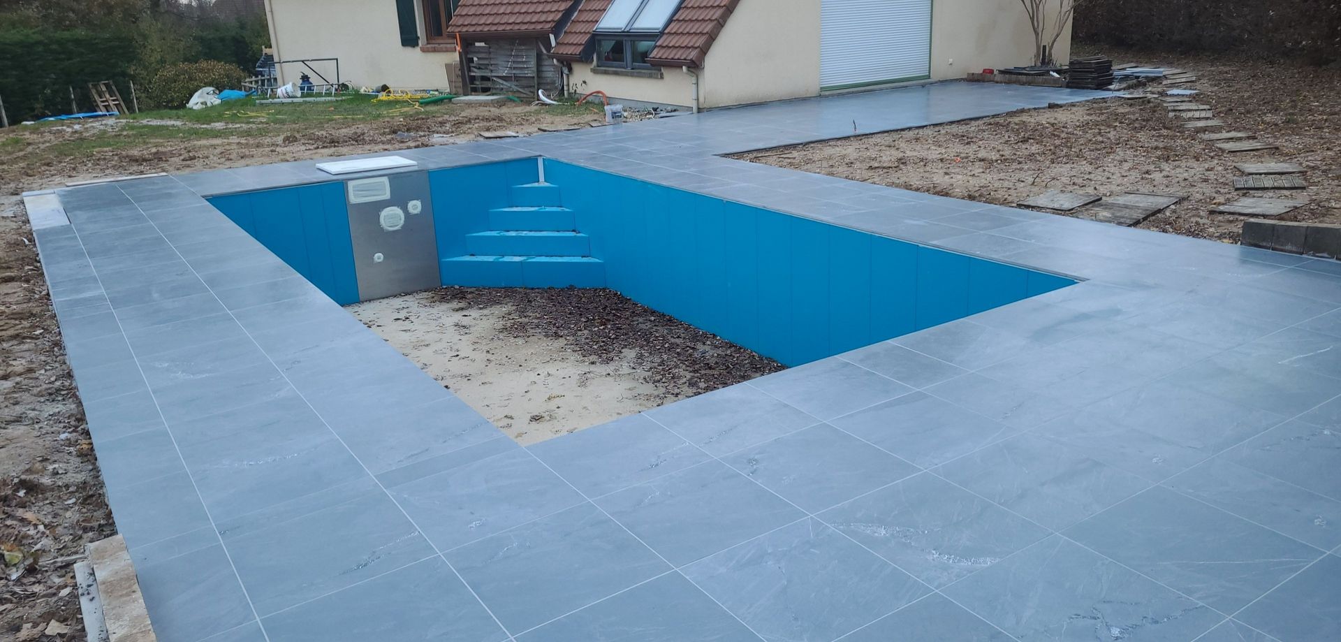 Tour de piscine en carrelage gris.