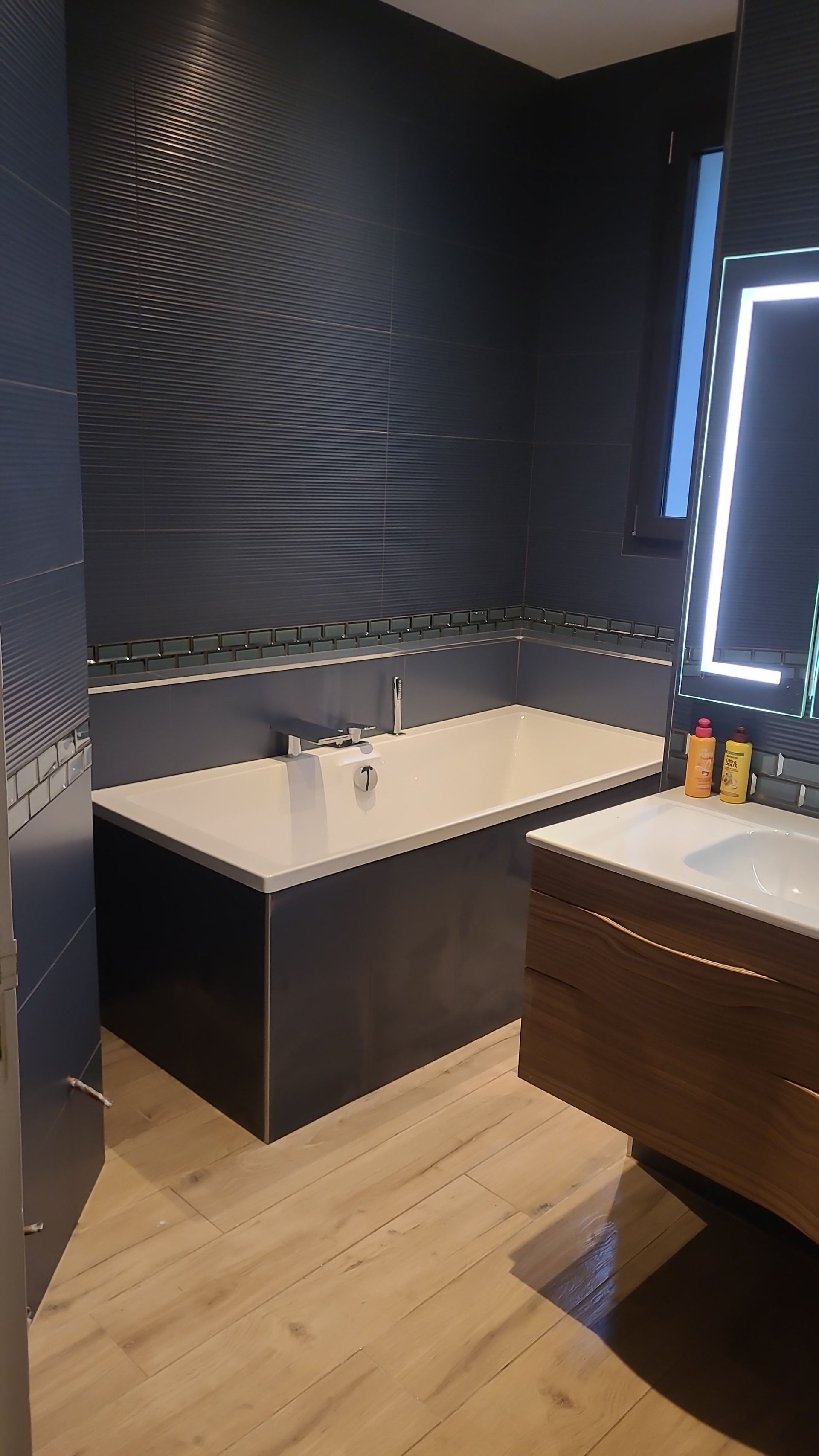 Salle de bains noire avec baignoire.