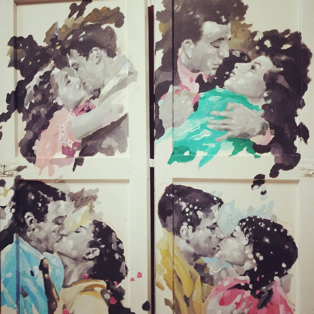 Cuatro cuadros de un hombre y una mujer besándose en una pared.
