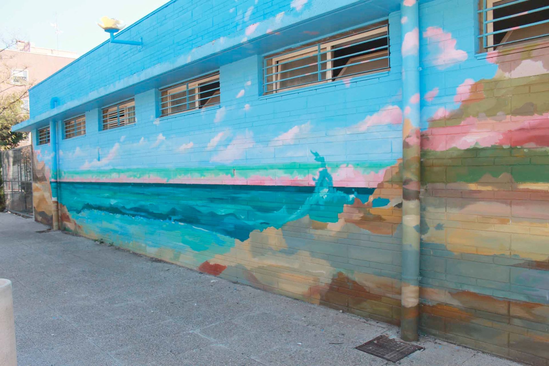 Un edificio azul con una pintura del océano en el costado.