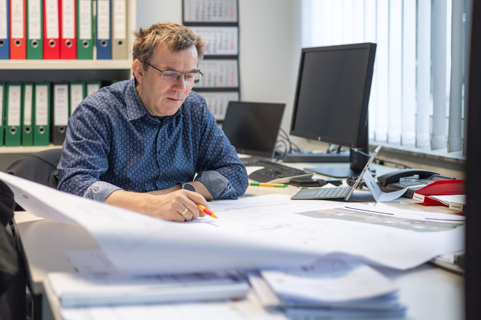 Ein Mann sitzt an einem Schreibtisch vor einem Computer.