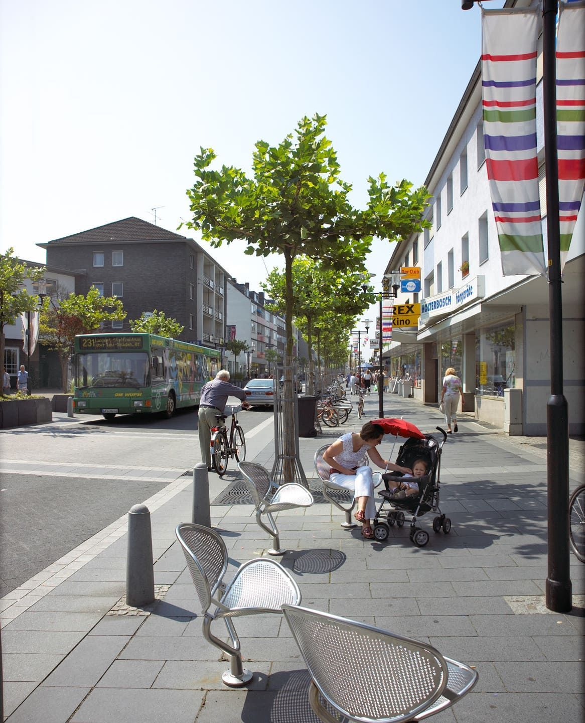 Ein Bürgersteig, der zu einem Gebäude mit Bäumen an der Seite führt.