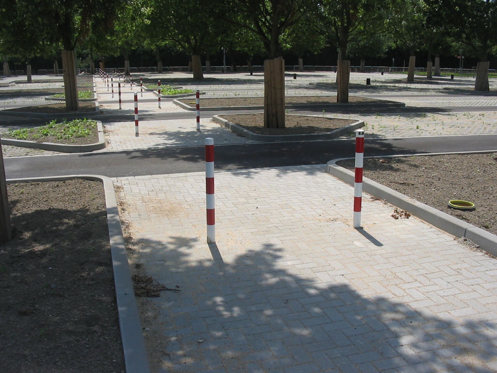 Eine Reihe rot-weißer Pfosten auf einem Parkplatz