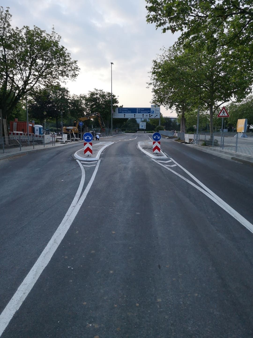Eine Straße mit weißen Linien und einem blauen Gebäude im Hintergrund