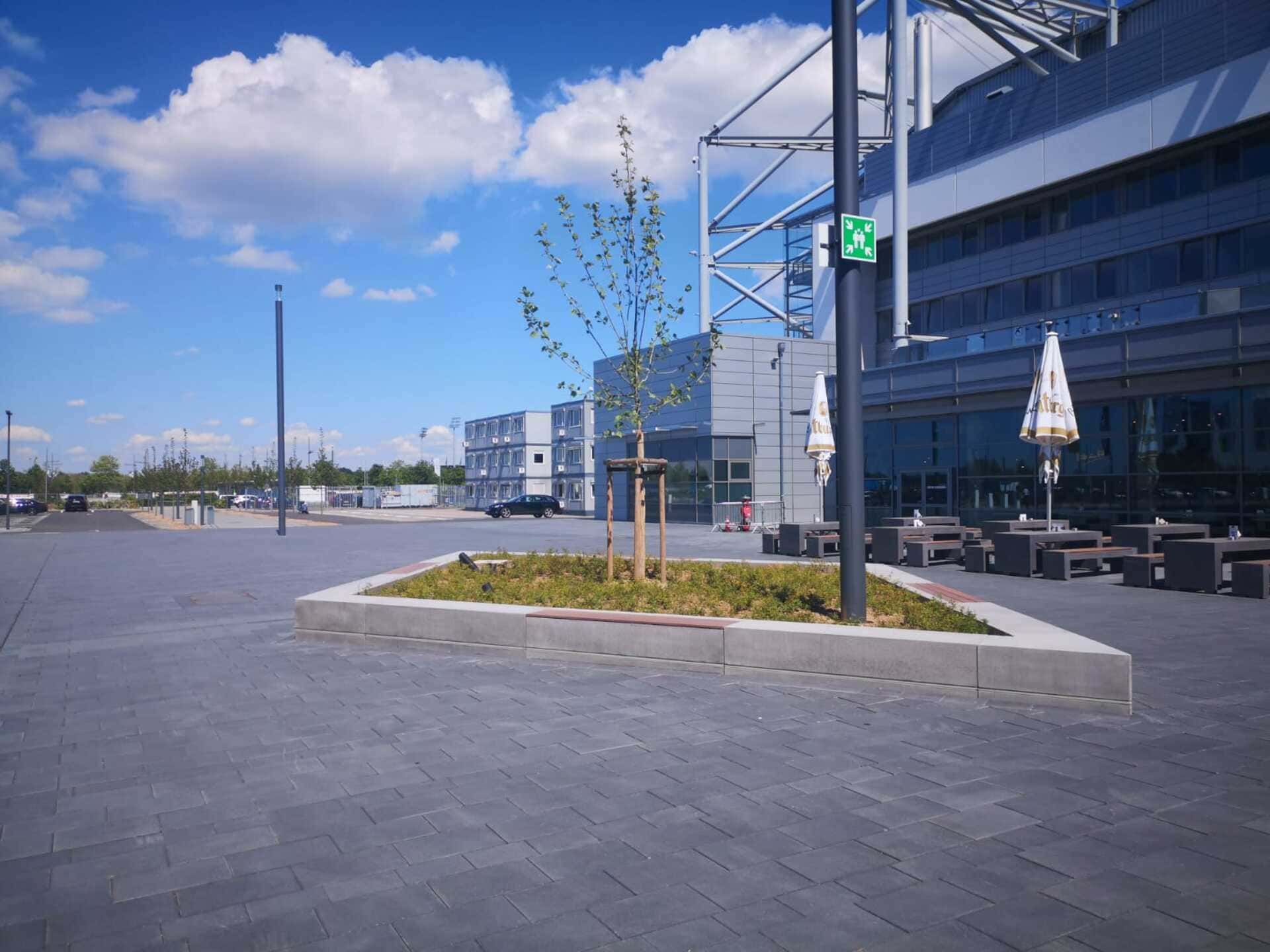 Ein großes Gebäude mit Tischen und Stühlen davor.