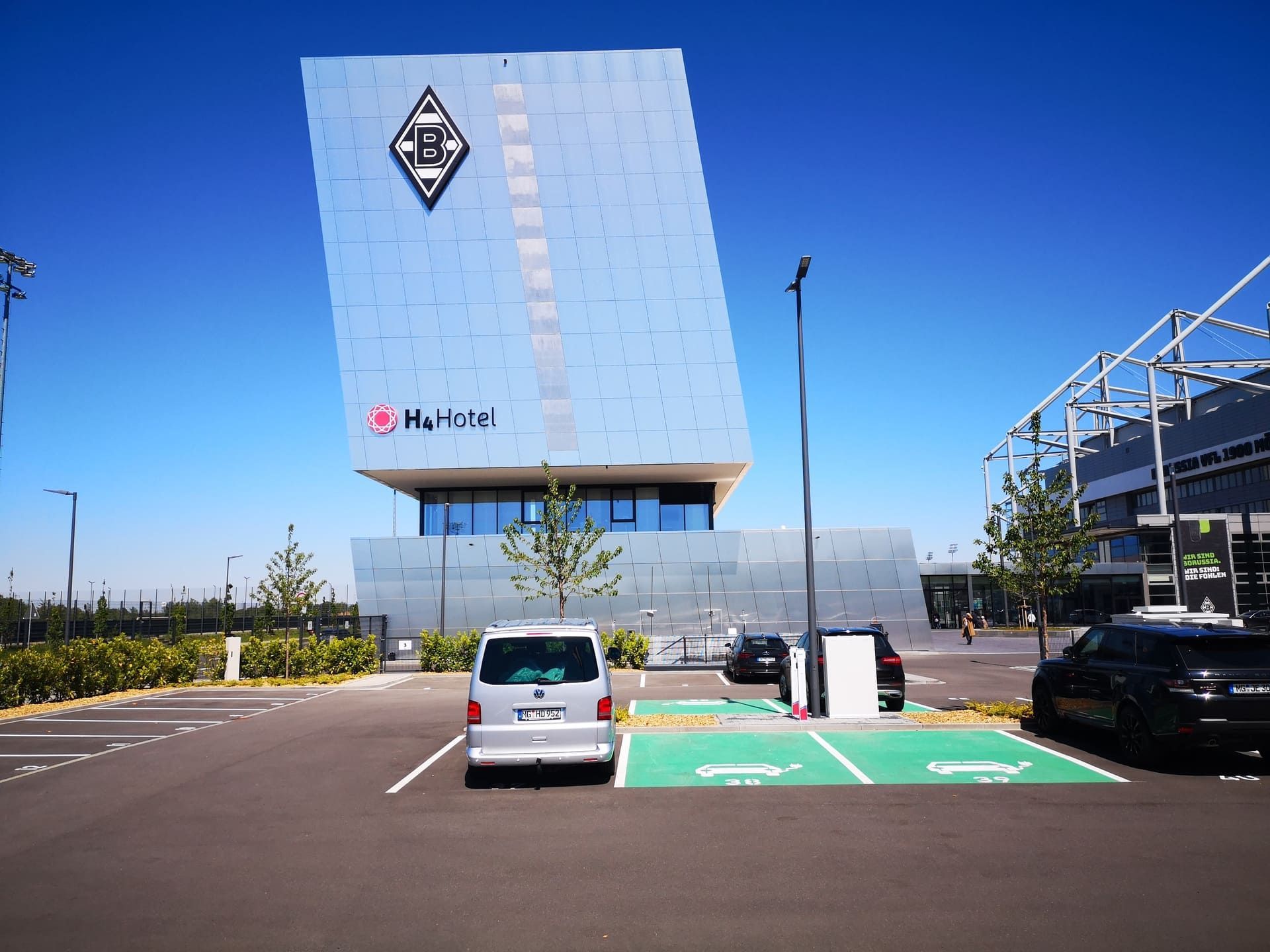 Ein Lieferwagen steht auf einem Parkplatz vor einem großen Gebäude