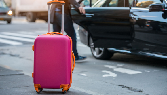 Une valise dans une rue de la ville, à côté d'une voiture.