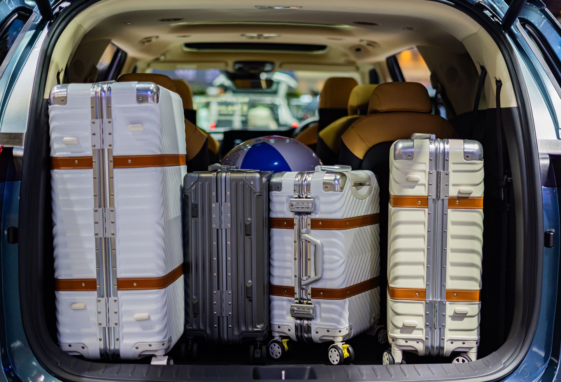 Des bagages rangés dans le coffre de la voiture, comprenant plusieurs valises et un casque.