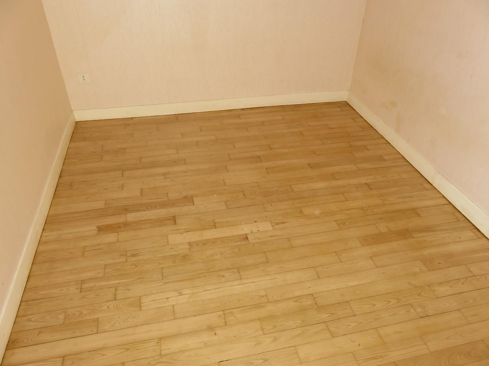 Parquet d'une pièce aux murs rose pâle