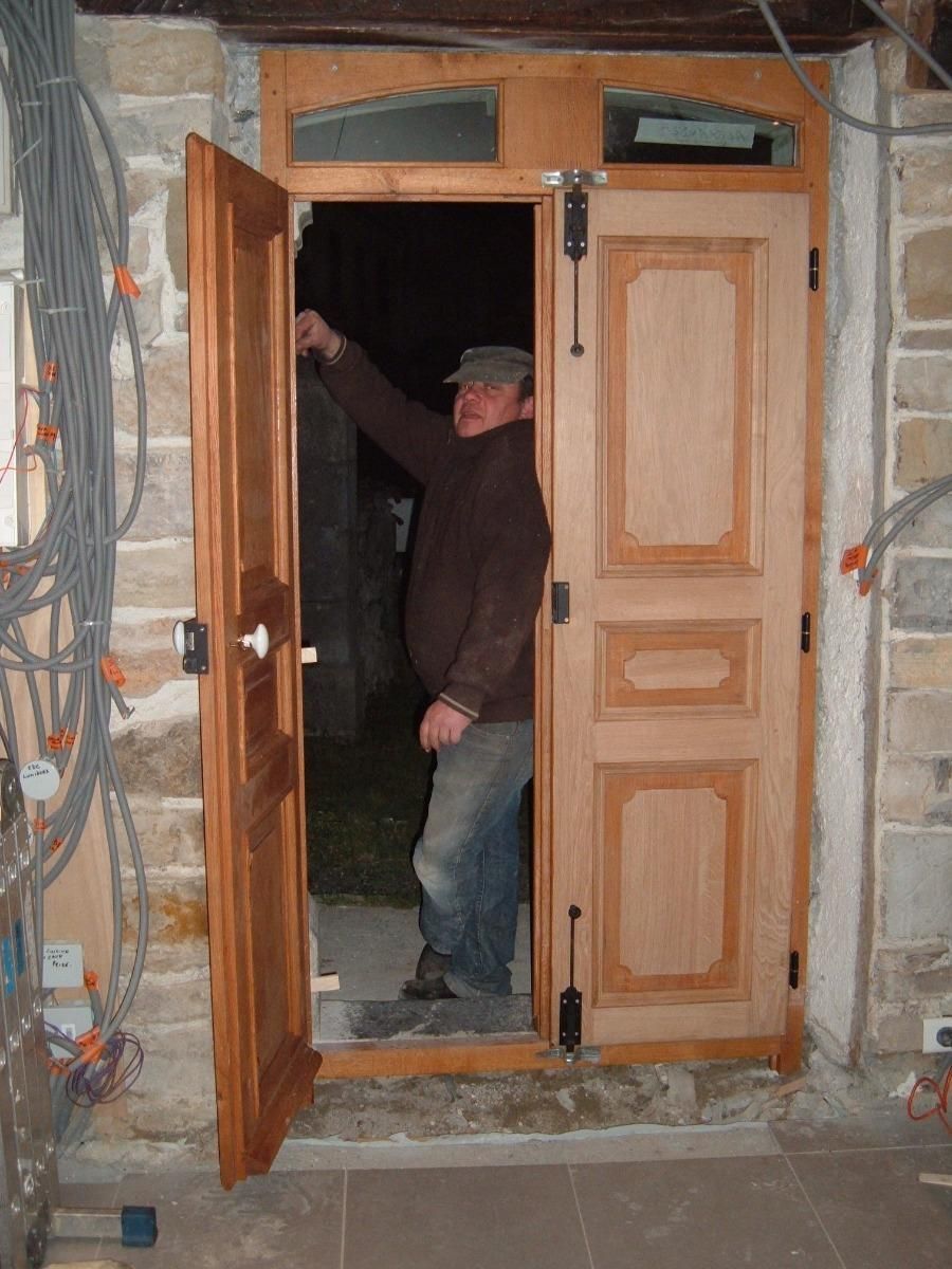 Homme dans l'ouverture d'une des deux portes en bois