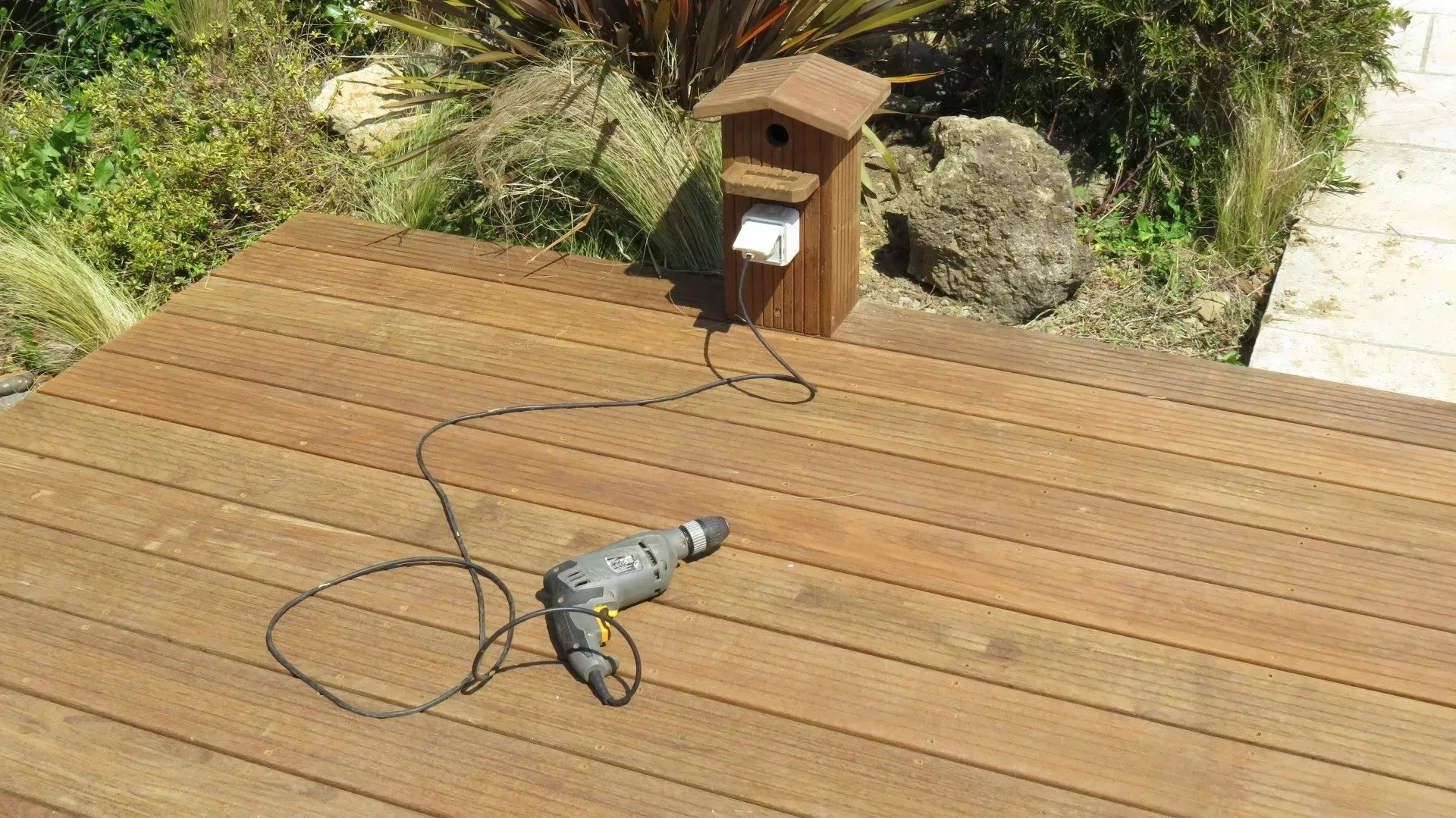 Perceuse branchée sur une terrasse en bois