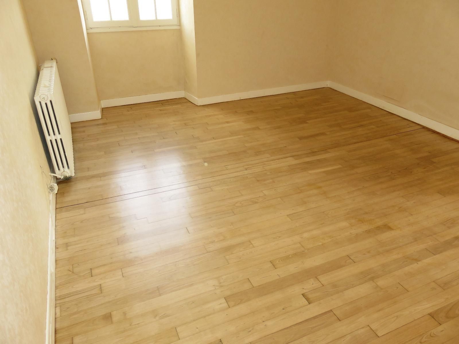 Parquet en bois d'une pièce vide avec une fenêtre