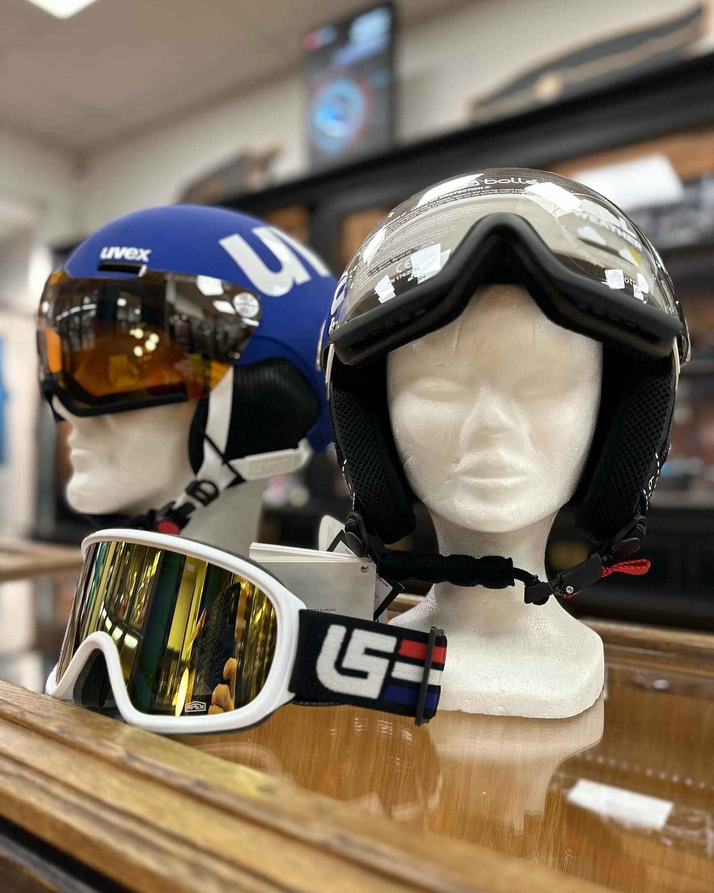Deux casques de ski sur des têtes de mannequin, ainsi qu'une paire de lunettes de ski.