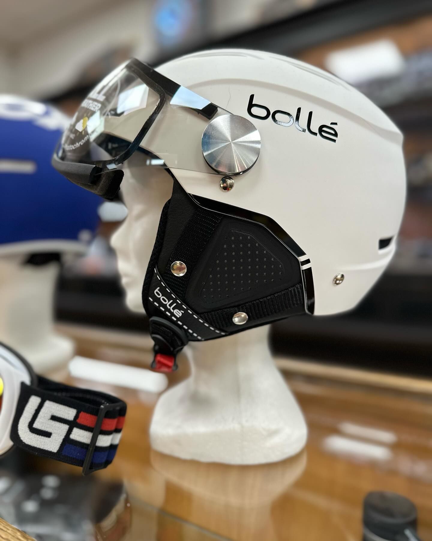 Casque de ski blanc sur une tête de mannequin avec visière.