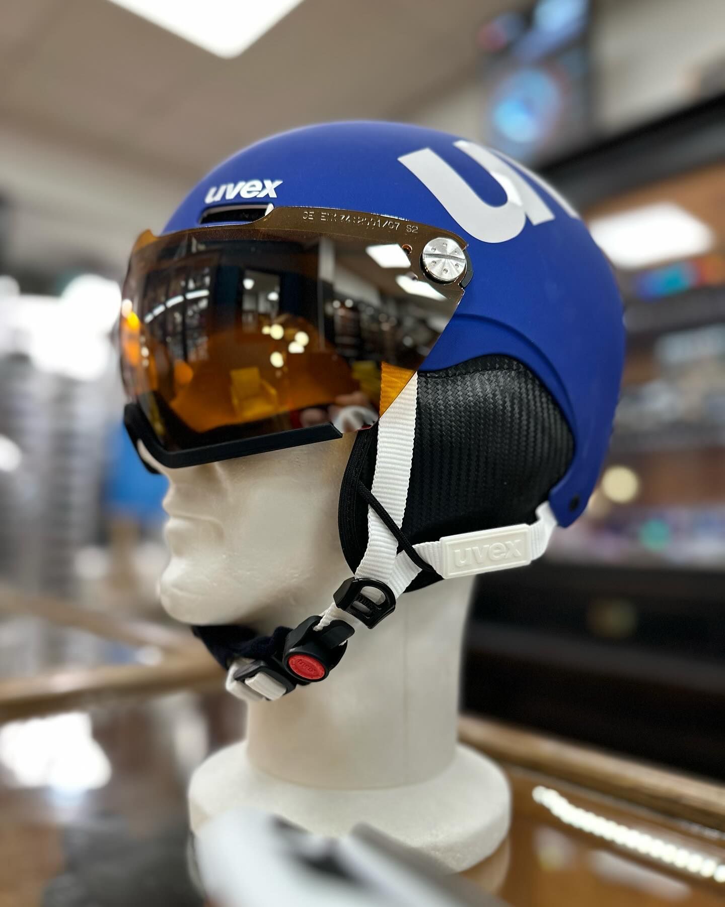 Casque de ski bleu avec visière orange sur une tête de mannequin.