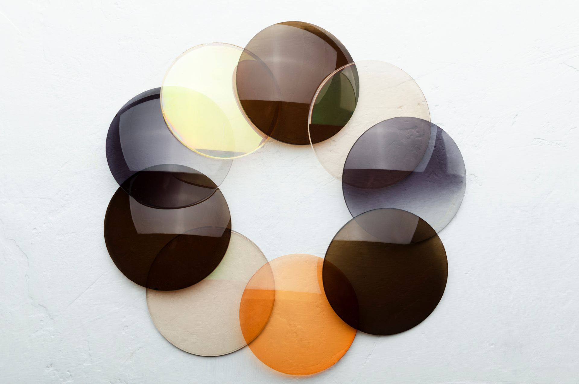 Disposition circulaire de verres de lunettes de différentes couleurs.