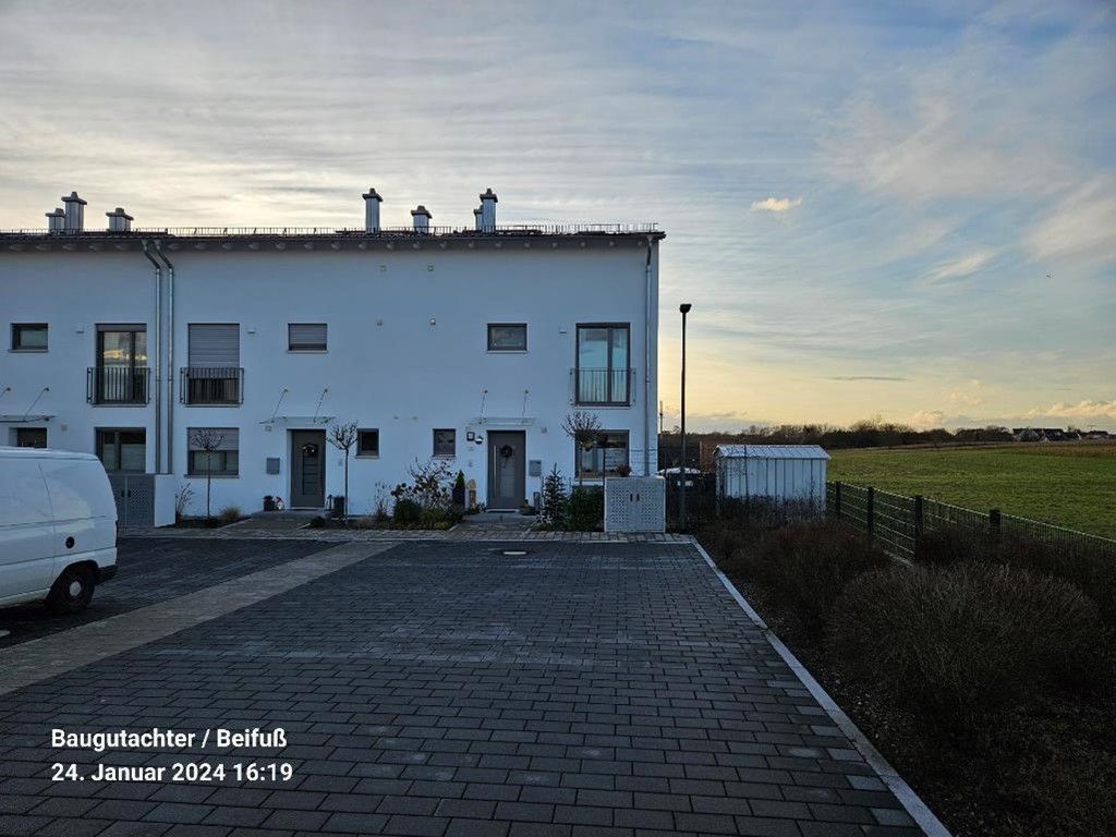 Bausachverständiger für Immobilienkaufberatung und Hauskaufberatung in Freising. Ein weißes Haus mit Garagentor und Treppe. Immobilienkaufberatung und Hauskaufberatung Freising.