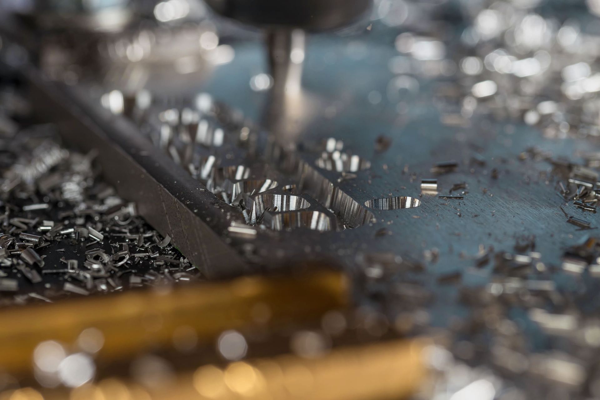 Un primer plano de una broca cortando un trozo de metal.