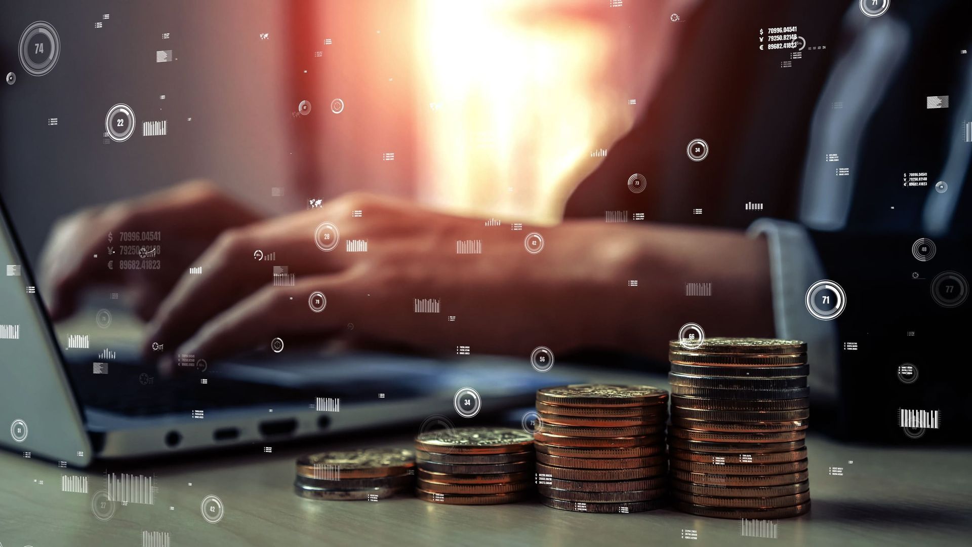 Un hombre está escribiendo en una computadora portátil al lado de una pila de monedas.