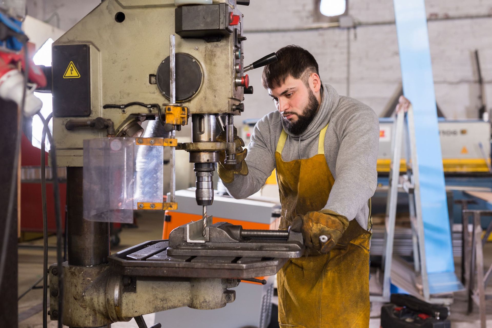 Un hombre está trabajando en una máquina en una fábrica.