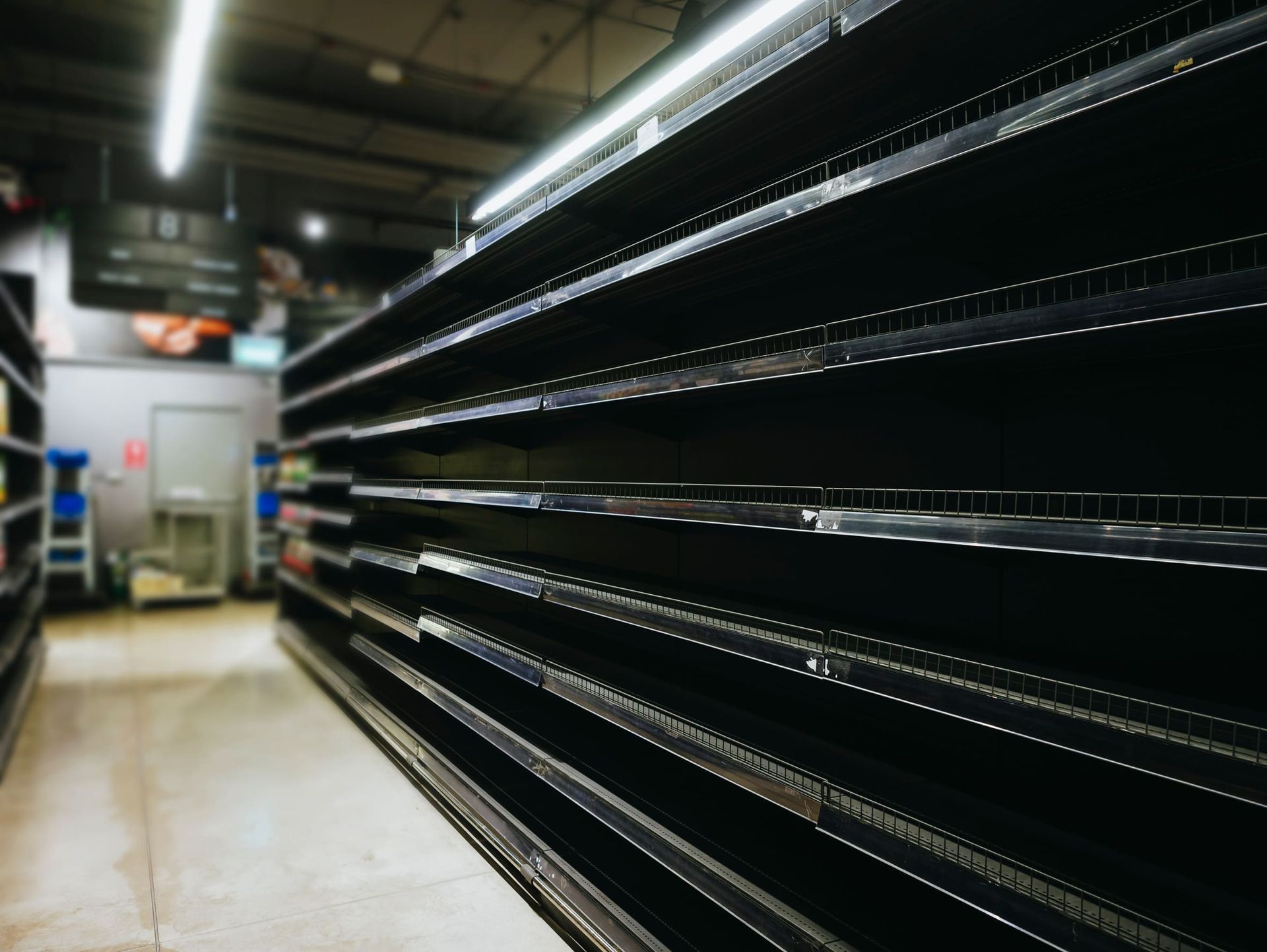 Una fila de estantes vacíos en una tienda de comestibles.