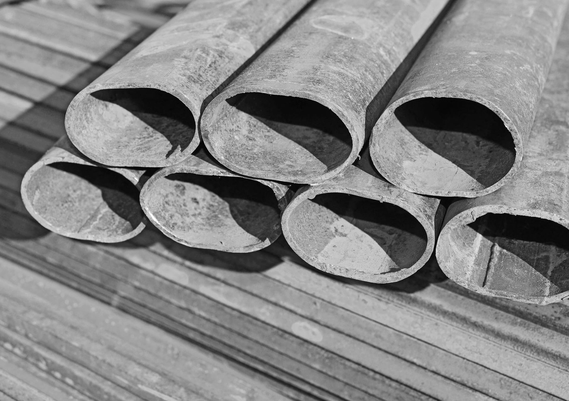 Una fotografía en blanco y negro de una pila de tubos de metal.