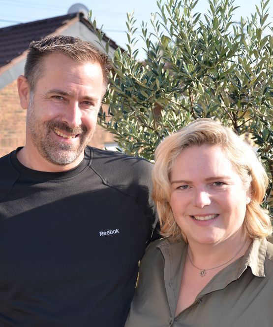 Ein Mann und eine Frau posieren vor einem Baum für ein Foto.