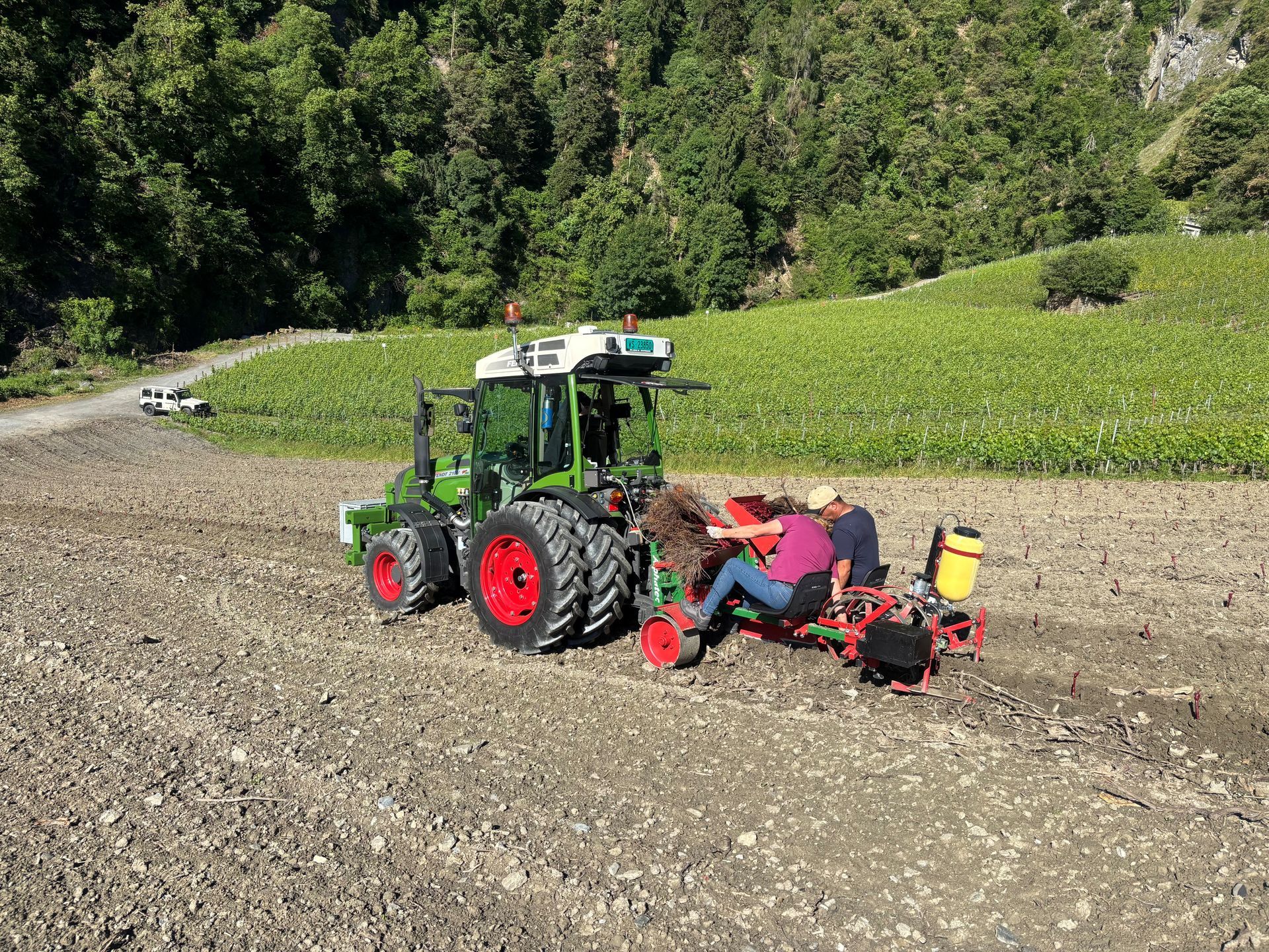 Un tracteur tracte une remorque frigorifique à l'intérieur d'un entrepôt ; un autre tracteur se trouve à l'arrière-plan, près d'une porte de chargement ouverte.