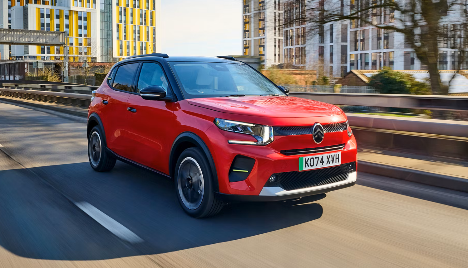 Citroën C5 X bleue roulant sur une route sinueuse avec un arrière-plan naturel.