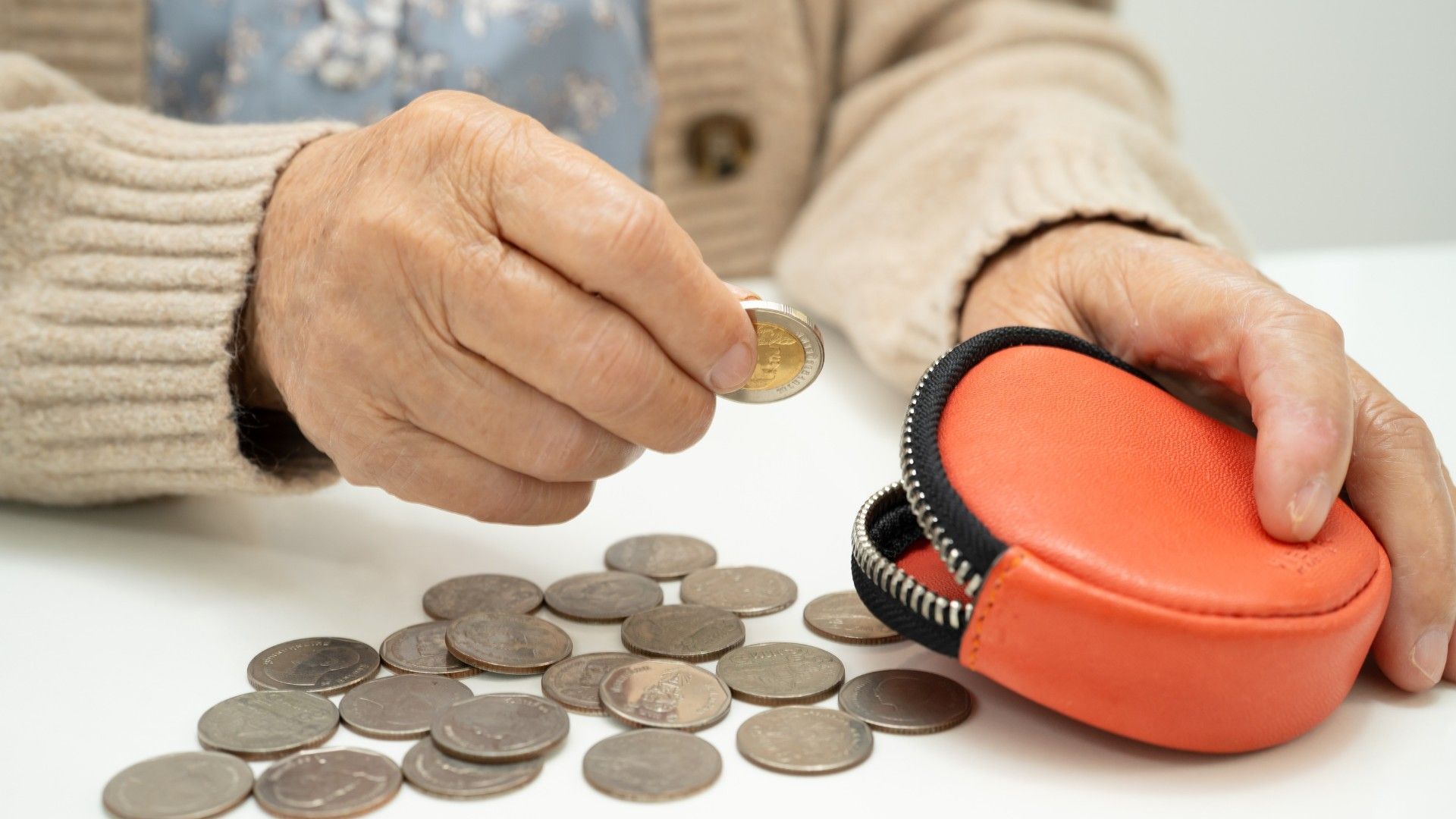 Münzen werden in Geldbrse gesteckt