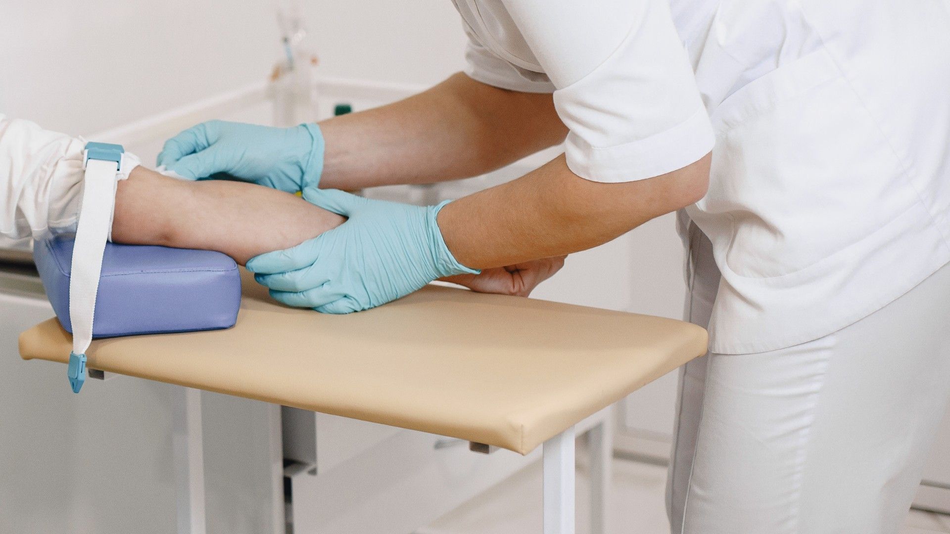 Pflegepersonal nimmt Blut ab im Arm