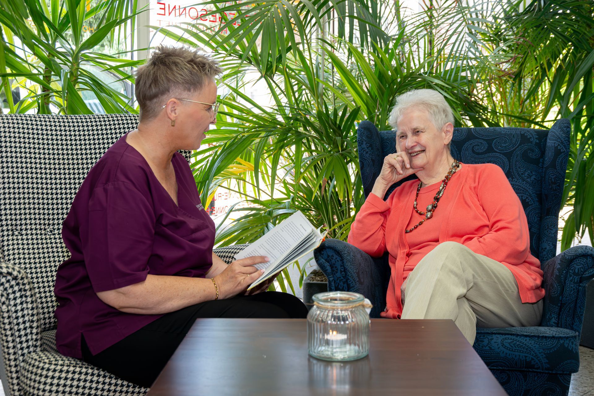 Pflegekraft liest alter Dame vor