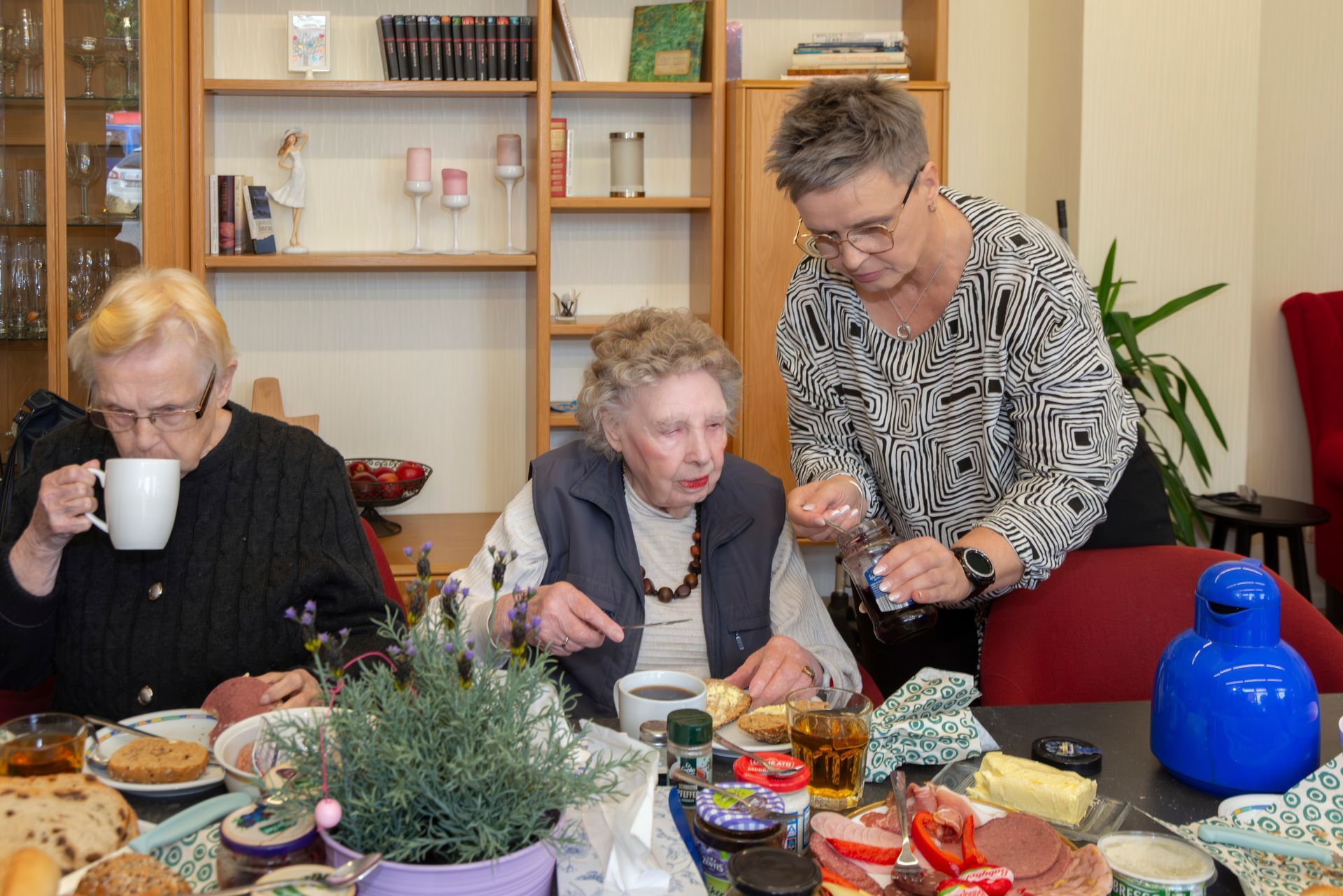 Pflegerin hilft Seniorin bei der Zubereitung des Essens