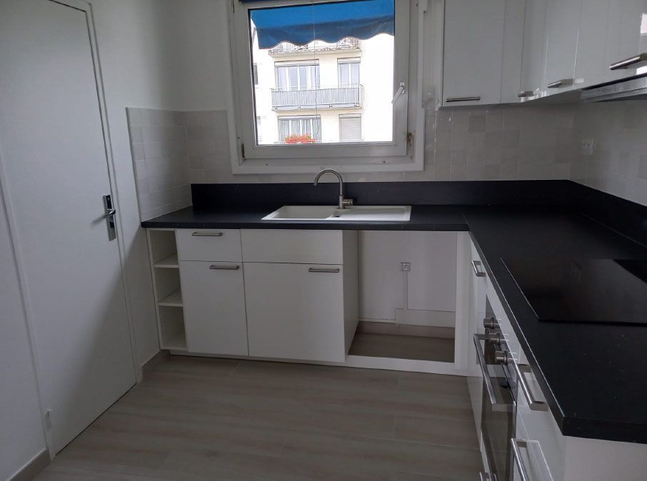 Cuisine avec plan de travail noir et meubles blancs