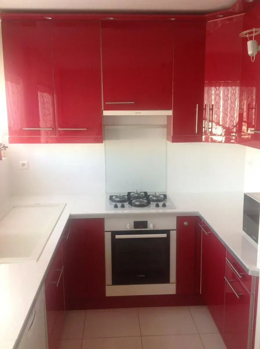 Cuisine avec plan de travail blanc et meubles rouges
