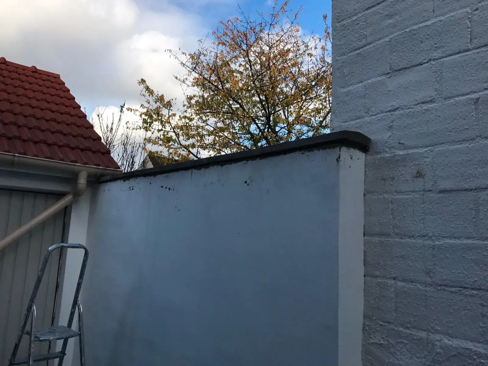 Mur blanc à l'extérieur avec un petit escabeau