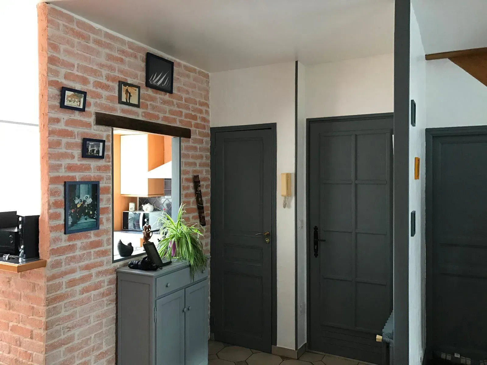 Intérieur d'une maison avec mur en briques et portes gris foncé