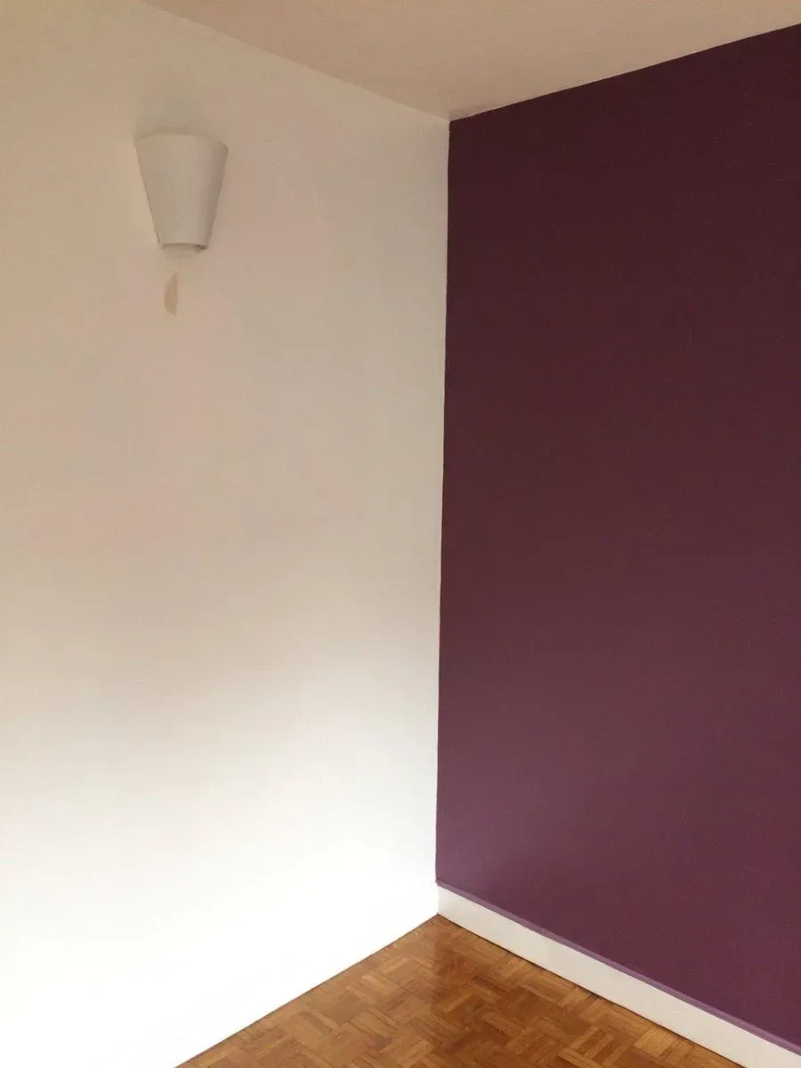 Coin de pièce avec un mur couleur de prune et l'autre blanc