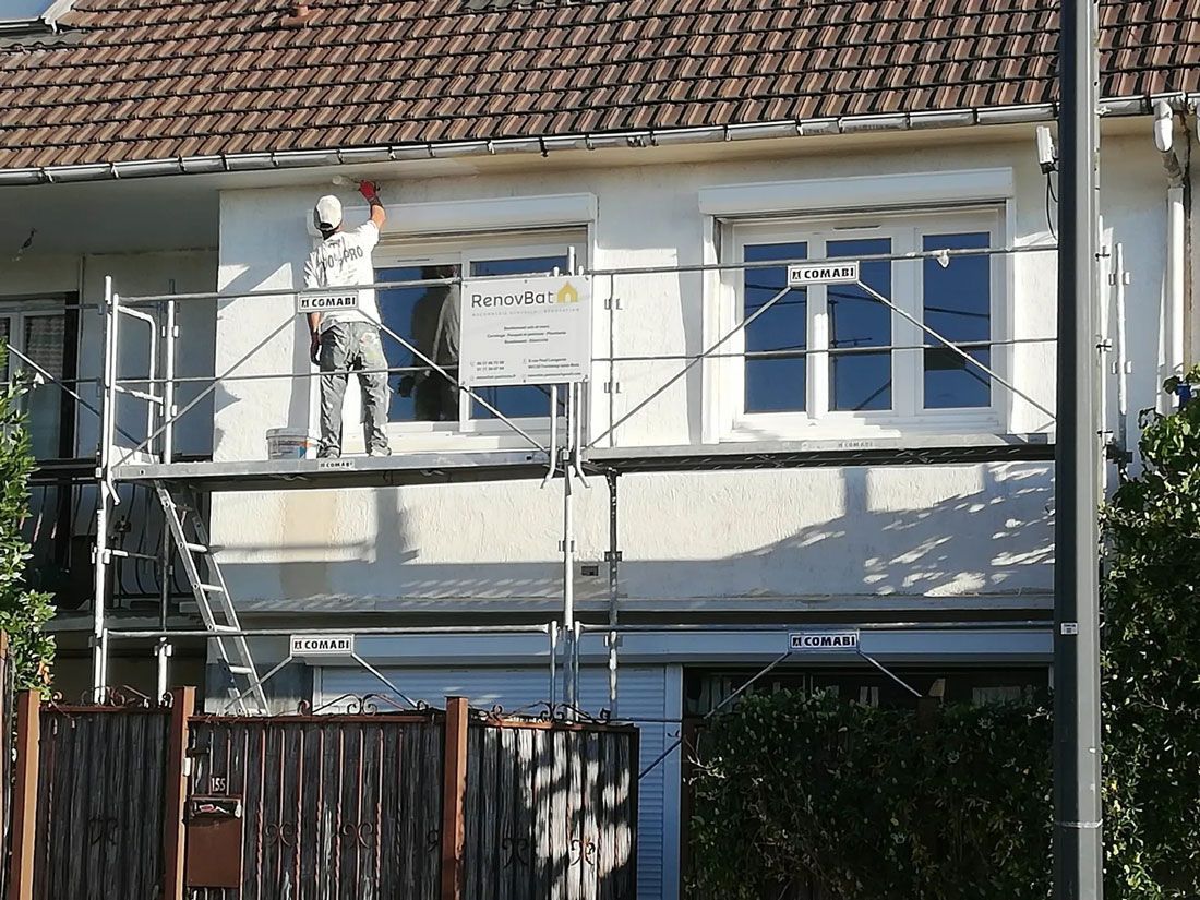 Professionnel sur un échafaudage RenovBat en train de repeindre une façade