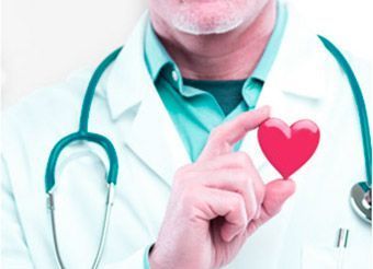Un médico sostiene un corazón rojo en su mano.